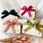 Four gift boxes with colorful ribbons on a white fabric background