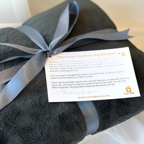 Gray textured blanket with a ribbon and care label on a white background