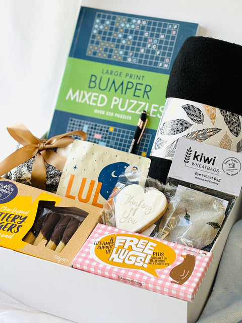 Assorted items including a book, cookies, and wheat bags on a white surface.