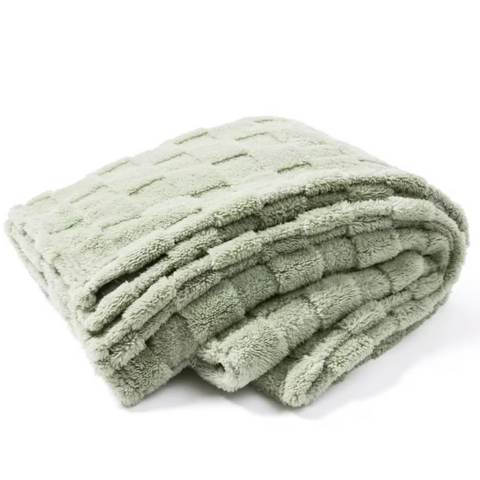 Folded green blanket on a white background