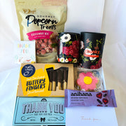 Assorted snacks and treats including popcorn, candies, and chocolate bars on a white background