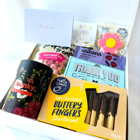 Assorted food items and cards in a box on a white background