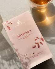 Anxielea tea packet with a glass of tea in the background