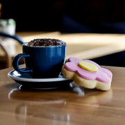 Coffee and a floral cookie on a wooden table