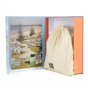 Drawstring bag with branding in an open box displaying a beach scene of Mt Maugnanui