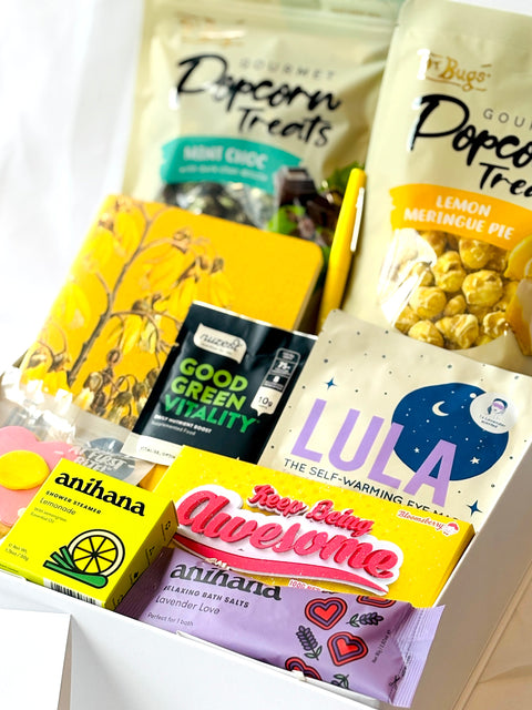 Assorted products including bags of popcorn treats and boxes with branding on a white background